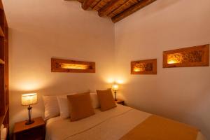 a bedroom with a white bed with two lamps at Tala Huasi in Tilcara +82 photos