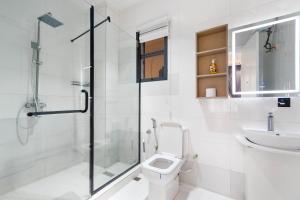 a bathroom with a shower and a toilet and a sink at Casa Aurelia Penthouse in Lekki +21 photos