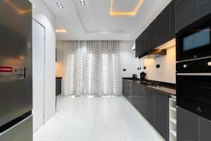 a kitchen with black cabinets and a white floor at Casa Aurelia Penthouse in Lekki