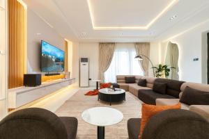 a living room with a couch and a flat screen tv at Casa Aurelia Penthouse in Lekki