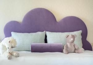 two stuffed animals sitting on top of a bed at Hôtel Métropole Monte-Carlo in Monte Carlo