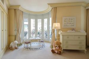 a room with two teddy bears and a dresser and a window at Hôtel Métropole Monte-Carlo in Monte Carlo