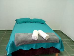 a bed with two rolled up towels on it at Pousada Almeida in Iguape