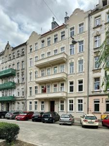 a large building with cars parked in front of it at K26UrbanNest in Wrocław