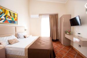 a hotel room with a bed and a television at ACIKA apartments in Rafailovici