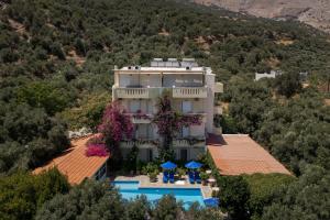 Una vista aérea de un edificio con piscina y árboles. en Sunrise Hotel & Apartments, en Rodakino