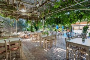 a restaurant with tables and chairs and a patio at Sunrise Hotel & Apartments in Rodakino