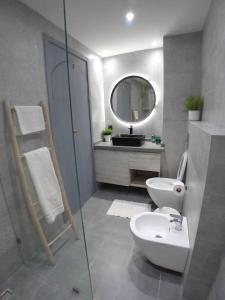 a bathroom with a sink and a toilet and a mirror at La Villa Atlantis in Agadir