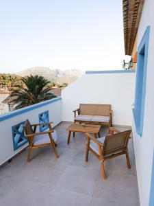 a balcony with two benches and a table and chairs at l'Alqueria de Laguar - Casa rural al Barranc de l'Infern in Benimaurell