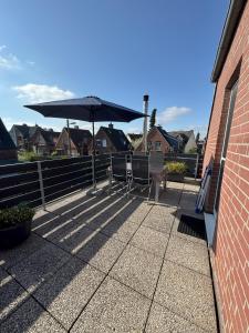 Ferienwohnung Heimathafen في لوبيك: فناء مع كرسيين ومظلة