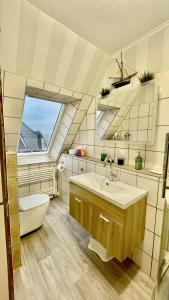 Ferienwohnung Heimathafen في لوبيك: حمام مع حوض ومرحاض ونافذة