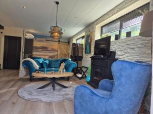 a living room with blue furniture and a fireplace at B&B Aquamarijn Katwijk in Katwijk aan Zee