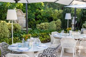 a patio with tables and chairs with umbrellas at Hôtel Métropole Monte-Carlo in Monte Carlo