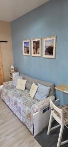 a bedroom with a bed with three pictures on the wall at Casa Relax in Nettuno