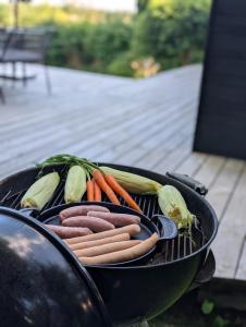 a grill with hot dogs and vegetables on it at Nordic Designer Summerhouse - With a fantastic view in Vejby +27 photos
