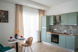 a kitchen with blue cabinets and a table and a table and a chair at Viroga Suite Apartments in Castel Volturno