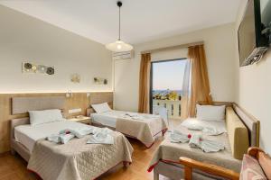 a hotel room with two beds and a window at Sunrise Hotel & Apartments in Rodakino +87 photos