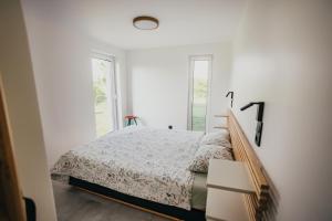 a white bedroom with a bed and a window at Śliwkowy Sad-Plum Orchard-Jura in Mirów