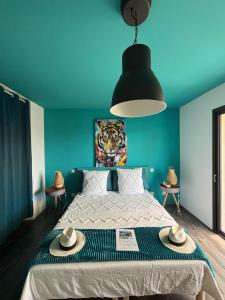 ein blaues Schlafzimmer mit einem Bett mit Hüten darauf in der Unterkunft Villa Marina in Sanary-sur-Mer