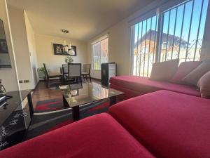 a living room with two red couches and a table at Casa amplia tres dormitorios 5 camas y estacionamiento in Padre Las Casas