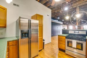 a kitchen with a stainless steel refrigerator and a stove at Deck and River View Loft in Downtown Hannibal in Hannibal