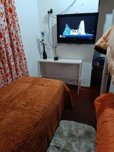 a bedroom with a bed and a tv on a wall at Irupe poty in Puerto Iguazú