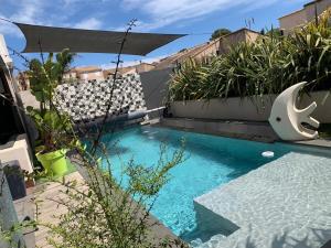 ein Pool mit blauem Wasser und einigen Pflanzen in der Unterkunft Villa Marina in Sanary-sur-Mer + 16 Fotos