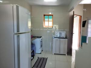 a kitchen with a refrigerator and a microwave at Chalé no Caborê in Paraty