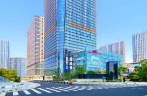 a large glass building in a city with tall buildings at Crowne Plaza Hangzhou Science City by IHG in Hangzhou