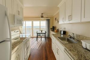 a kitchen with white cabinets and a view of the ocean at Ocean Haven Beachfront Getaway by Redondo Pier in Redondo Beach