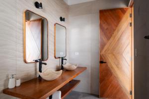 a bathroom with a wooden counter with two mirrors at Aviva, brand new designer luxury villa in Vichayito +31 photos
