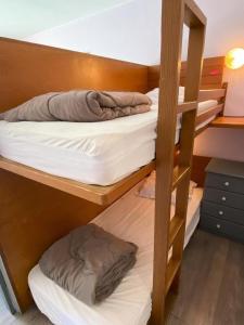 2 Etagenbetten in einem Zimmer mit einer Leiter in der Unterkunft Résidence Le Bois D'aurouze - Studio pour 4 Personnes MAE-7764 in Le Dévoluy