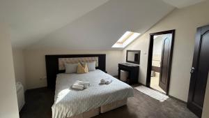 a bedroom with a bed with two towels on it at Геша Форест in Dryanovo