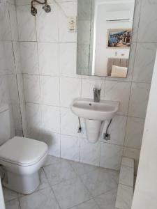 une salle de bains blanche avec toilettes et lavabo dans l'établissement Roof 2 Bedrooms sea view Green Beach 150, à El Alamein