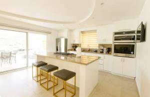 a kitchen with a large counter with stools in it at The Grande Nest in Oyster Pond