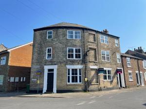 an old brick building on the corner of a street at Church Walk View Apartment Filey in Filey