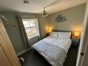a small bedroom with a bed and a window at Church Walk View Apartment Filey in Filey