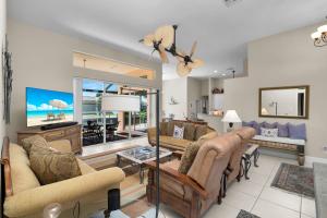 Marco Islandにある3 Bed 2 Bath Canal Home I Pool+Spa Gulf Accessのソファ2つとテレビのあるリビングルーム