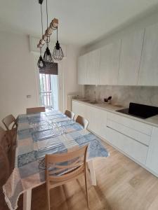 a kitchen with a table with chairs and a kitchen with white cabinets at Apartment Centre nhe in Lecco