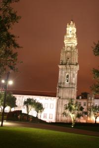 una torre del reloj alta frente a un edificio en 2U Oporto Urban Stays, en Oporto