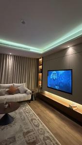 a living room with a couch and a large flat screen tv at شقه غرفه و صاله حي الملقا - نورسين in Quai