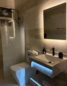 a bathroom with a sink and a toilet and a mirror at شقه غرفه و صاله حي الملقا - نورسين in Quai