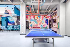 a ping pong table in a room with a mural at Loft Home Suites 118 By gA in Bogotá