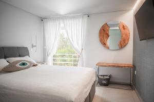 a bedroom with a bed and a mirror on the wall at El Mar, Pool House with 3 BDR, 7 min from beach in Saronida +19 photos