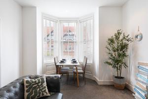 ein Wohnzimmer mit einem Tisch und einem Sofa in der Unterkunft Sea Shore Apartment in Llandudno