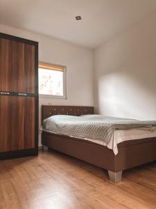 a bedroom with a bed and a wooden cabinet at U Tomasza in Śliwin
