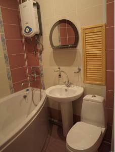 a bathroom with a toilet and a sink and a bath tub at Rent Zhytomyr Apart in Zhytomyr