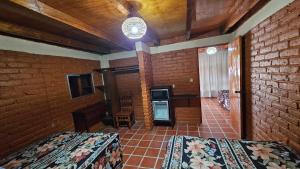 a bedroom with two beds and a brick wall at Hotel y Cabañas Manolo in El Pedregal