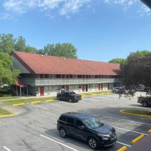 a car parked in a parking lot in front of a building at HomeTowne Studios by Red Roof Buffalo - Niagara Airport in Williamsville +32 photos