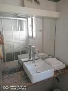 a bathroom with two sinks and a mirror at Herault Maraussan in Maraussan +6 photos